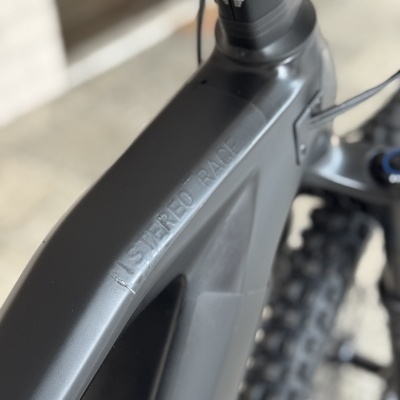 Quadro de bicicleta preto fosco com escrita SISTEREO RACE e pneus de cravos visíveis