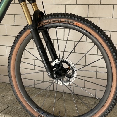 Roda dianteira de bicicleta com pneu castanho e preto e suspensão preta