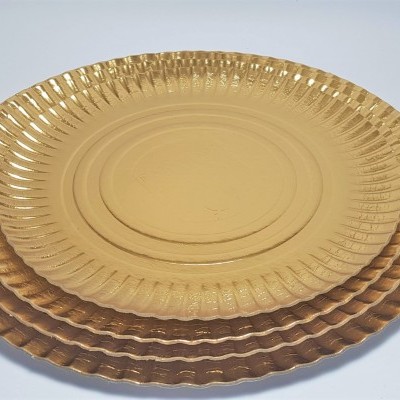 Três pratos dourados decorativos empilhados com padrão ondulado na borda