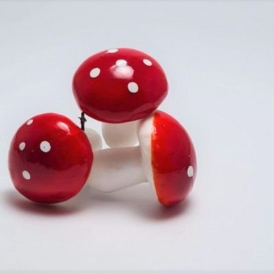 Ornamentos cerâmicos em forma de cogumelos vermelhos com manchas brancas