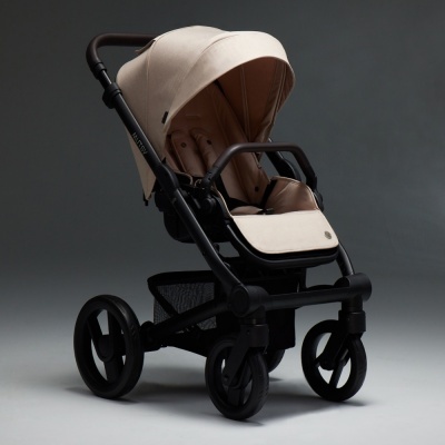 Carrinho de bebé bege com estrutura preta e capota ajustável