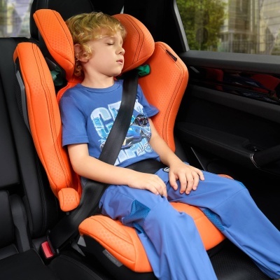 Cadeira auto laranja para criança no banco traseiro de carro com criança sentada a dormir