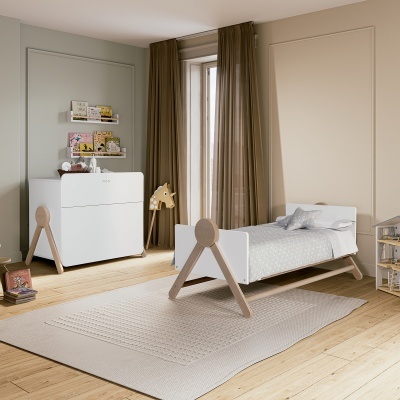 Quarto infantil com cama e cómoda em madeira clara, tapete bege e cortinas castanhas