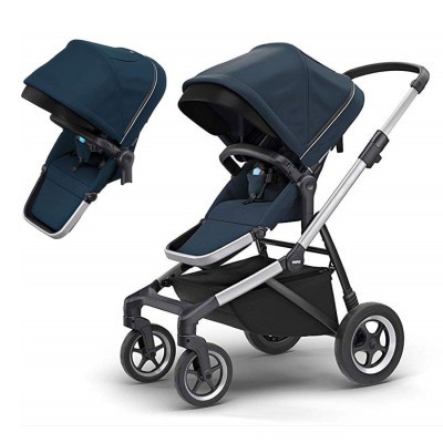 Carrinho de bebé azul escuro com estrutura prateada e rodas grandes