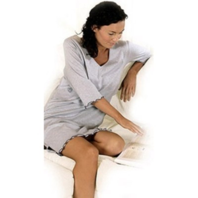 Mulher a ler no sofá com vestido cinza claro de manga comprida