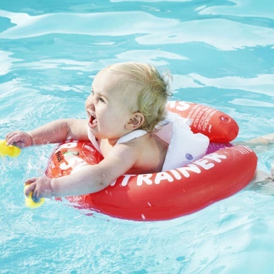 Bebé a flutuar numa piscina com bóia vermelha e brinquedos amarelos