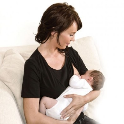 Mulher a amamentar bebé num sofá bege