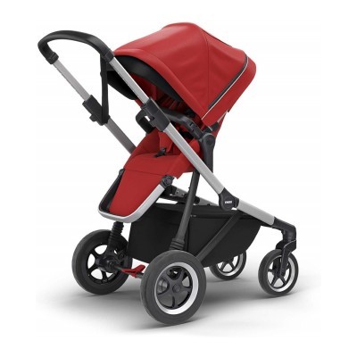 Carrinho de bebé vermelho com estrutura metálica cinza e pneus pretos