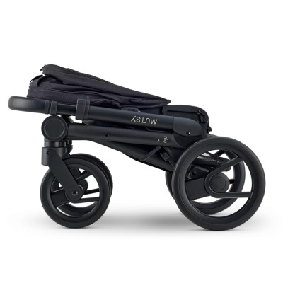 Carrinho de bebé dobrado preto com rodas grandes e texto MUTSY