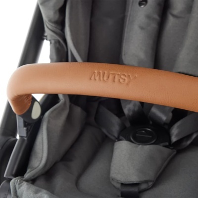 Carrinho de bebé cinza com barra castanha em pele marcada com 'MUTSY'