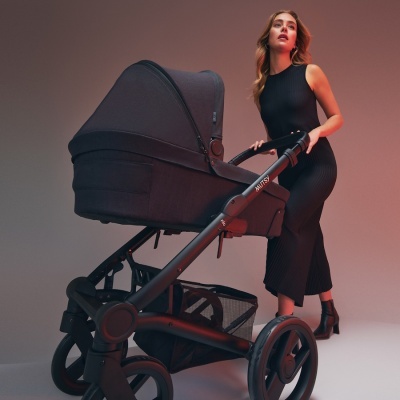 Carrinho de bebé preto com rodas grandes e mãe ao lado