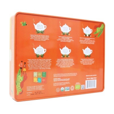 Lata metálica laranja com textos informativos sobre chá e ilustrações decorativas.