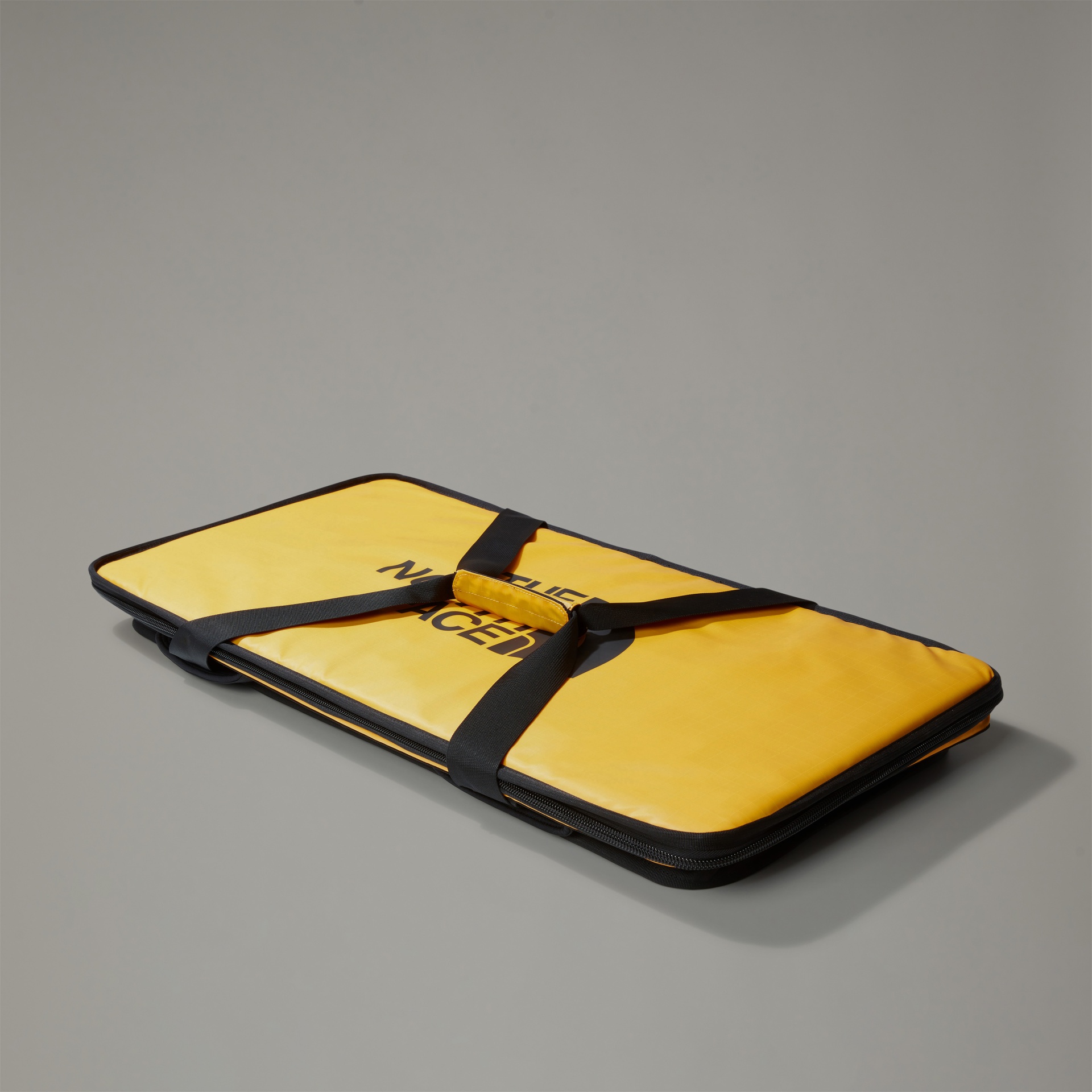 Estojo amarelo de transporte com alças pretas e texto THE NORTH FACE.
