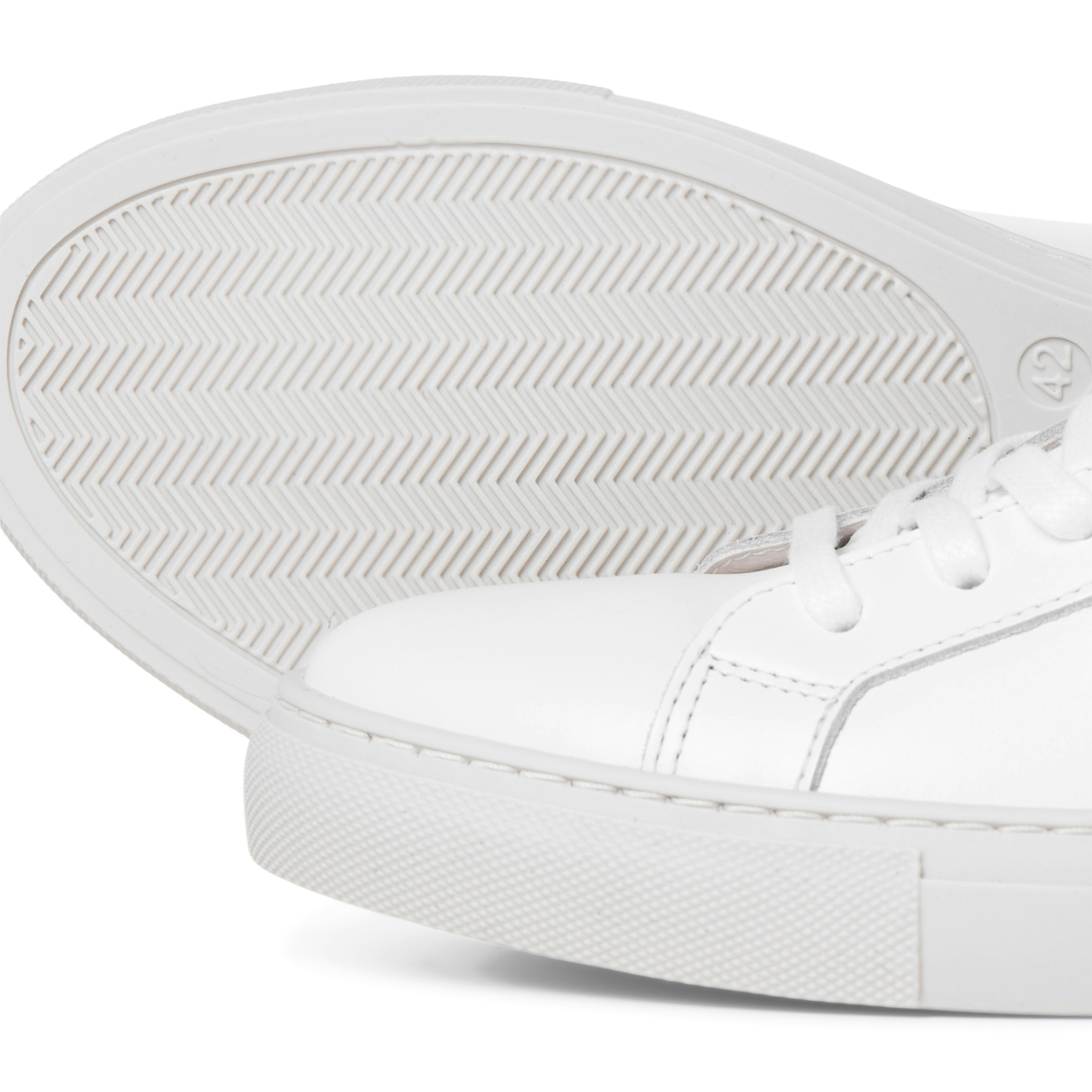 Sapatilha branca com sola riscada e atacadores brancos