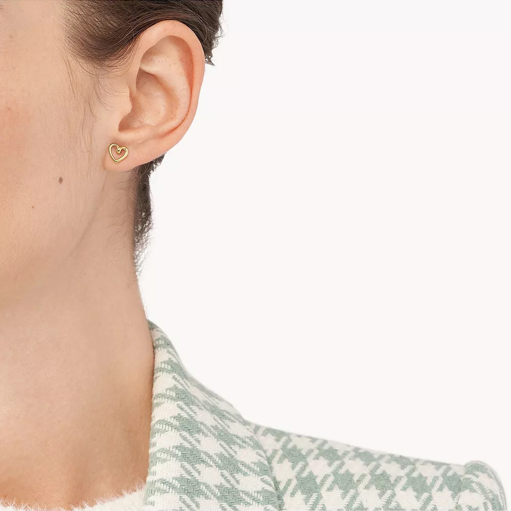 Brinco dourado em forma de coração na orelha esquerda