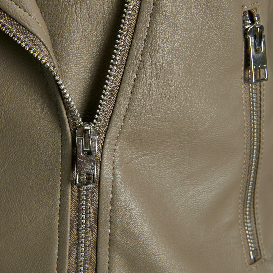 Fechos éclair prateados em casaco de couro bege claro