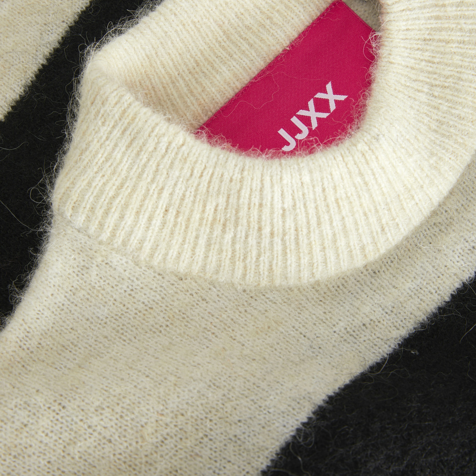 Camisola de malha creme e preta com etiqueta JJXX rosa interior.