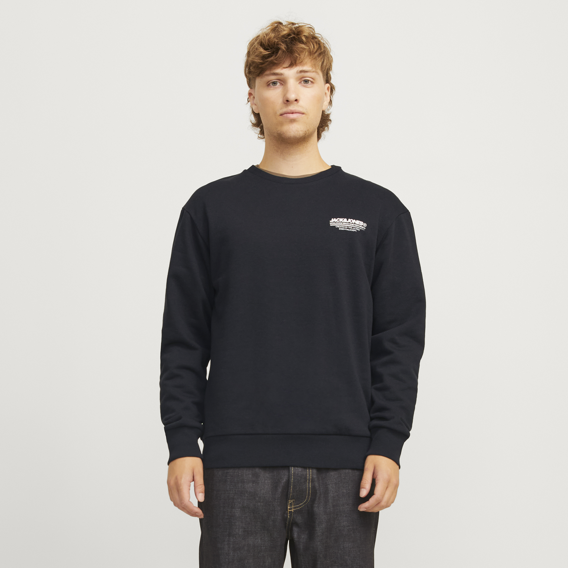 Camisola preta com texto branco no peito usada por modelo jovem