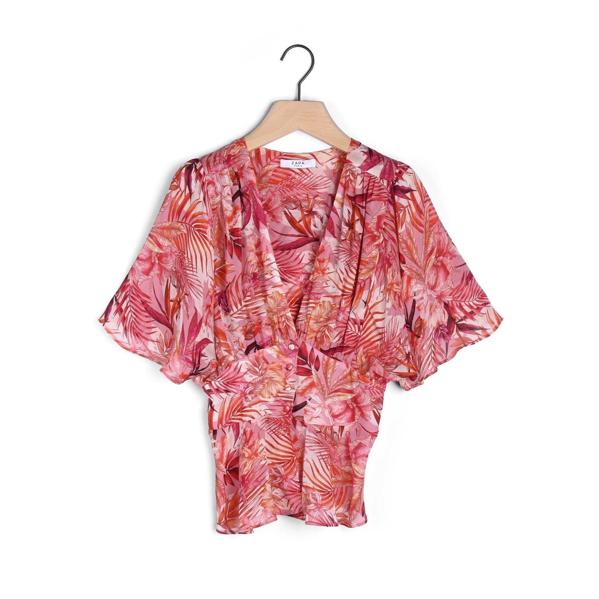Blusa feminina rosa com padrão floral pendurada num cabide de madeira