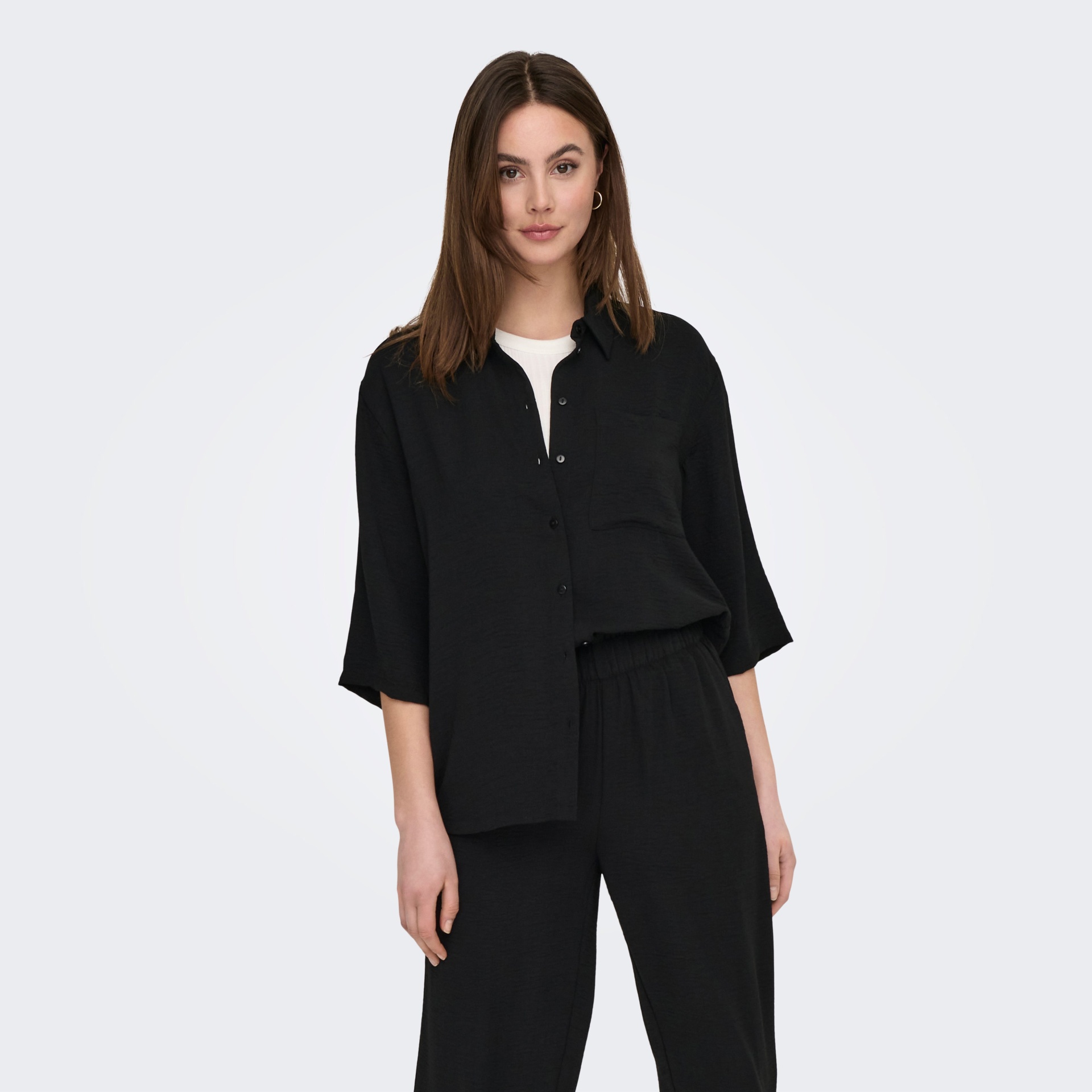 Mulher a vestir camisa preta e calças pretas