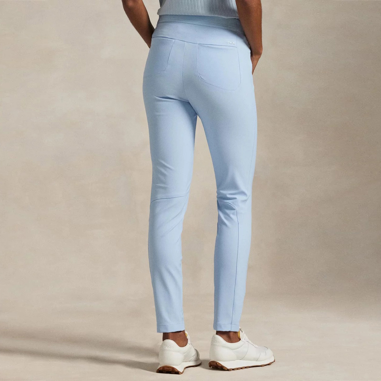 Calças azuis claras ajustadas com bolsos e sapatilhas brancas