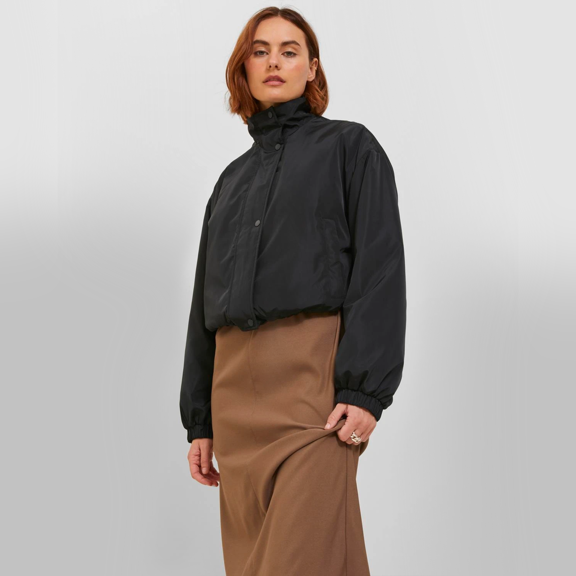 Mulher com casaco preto curto e gola alta