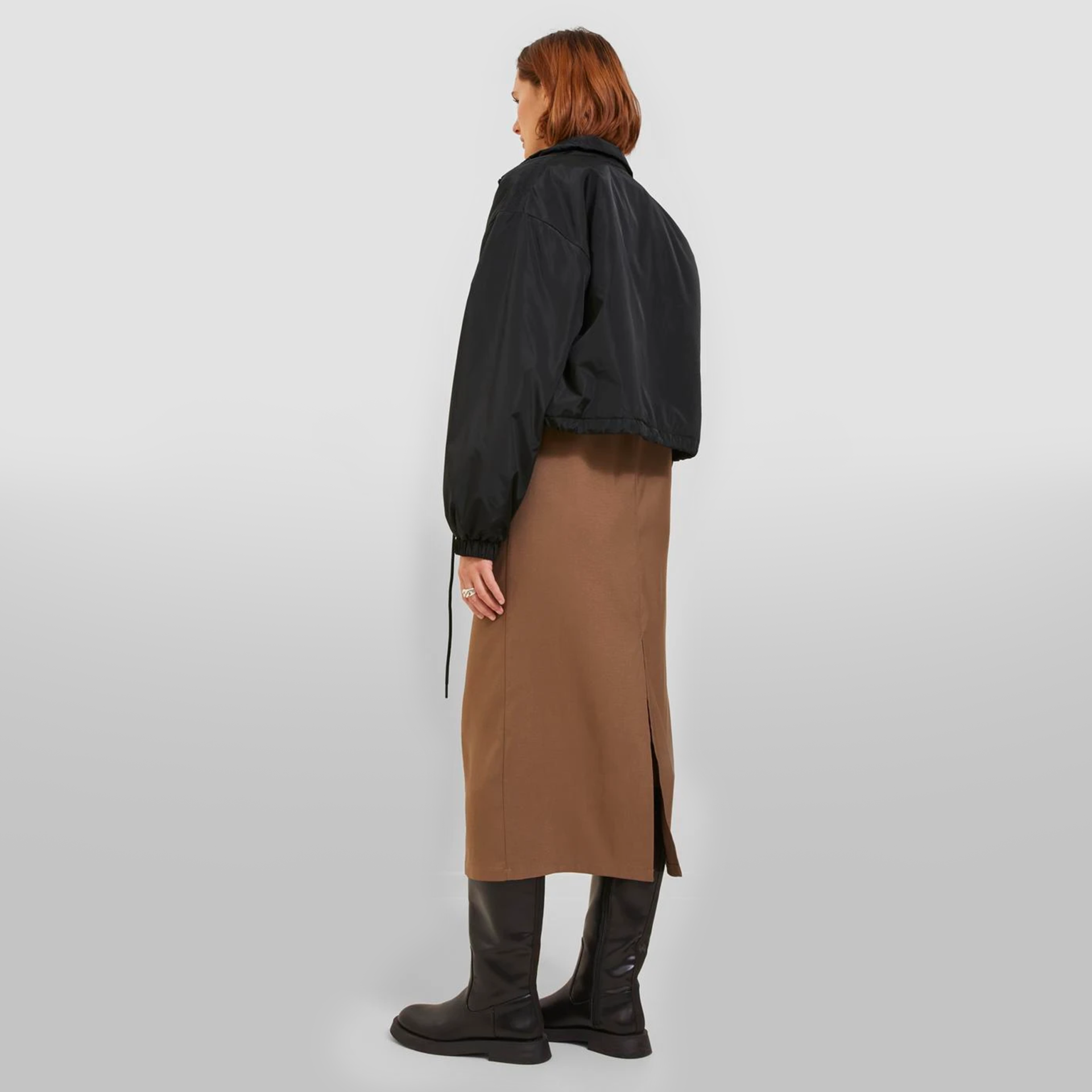 Casaco curto preto com saia castanha e botas pretas