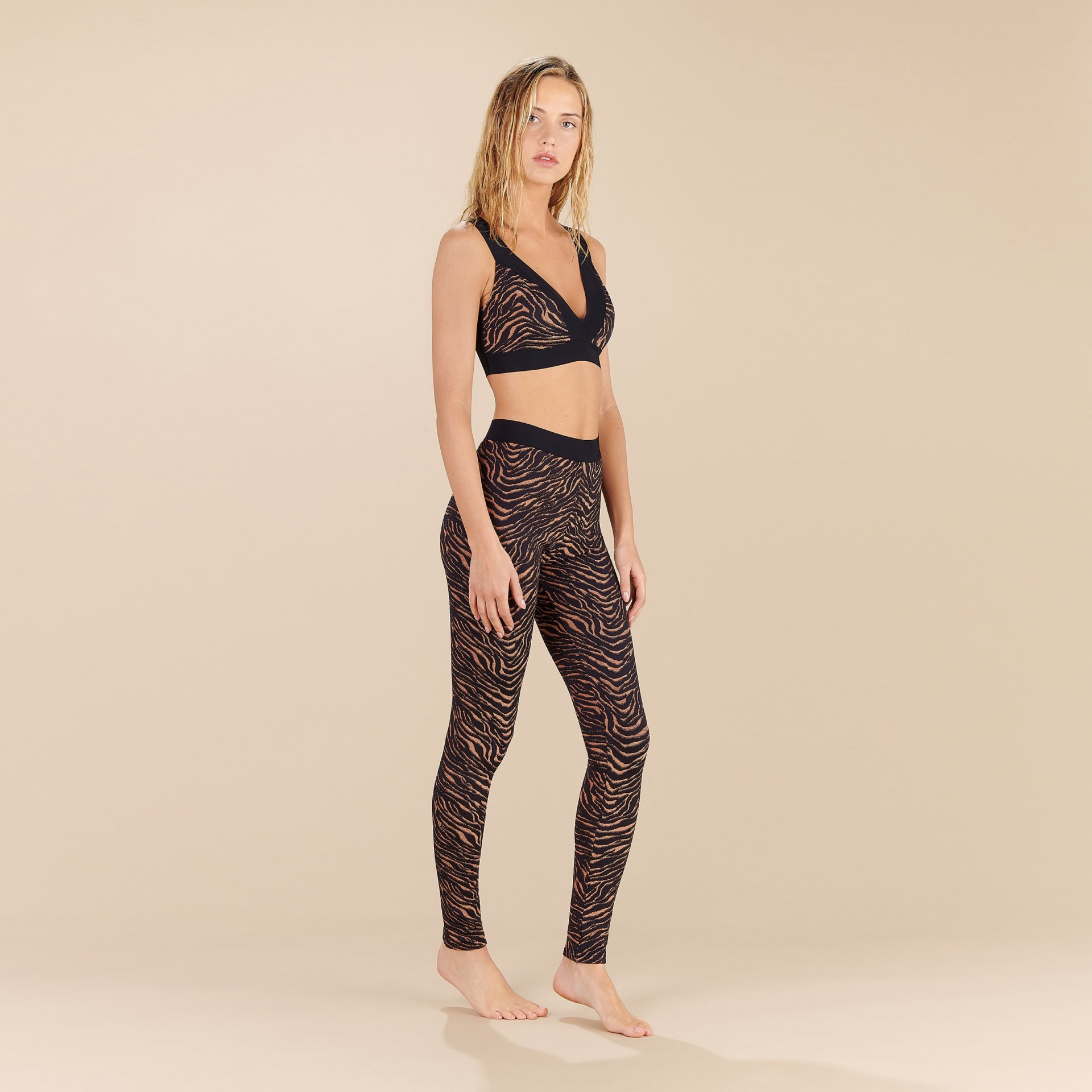 Conjunto desportivo feminino com top preto e leggings com padrão animal print