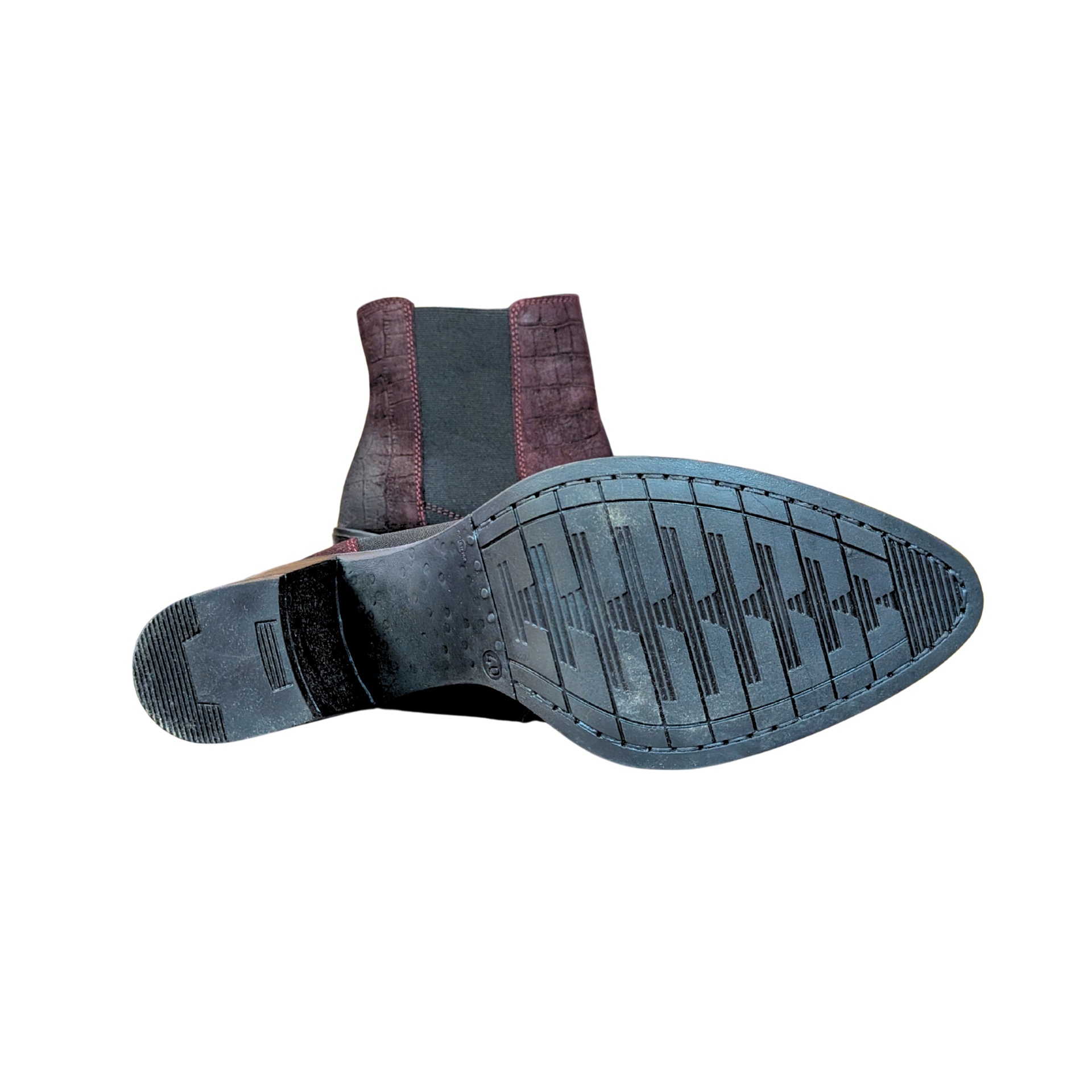 Botas de salto médio vista pela sola preta, textura antiderrapante e tecido elástico castanho escuro nas laterais.