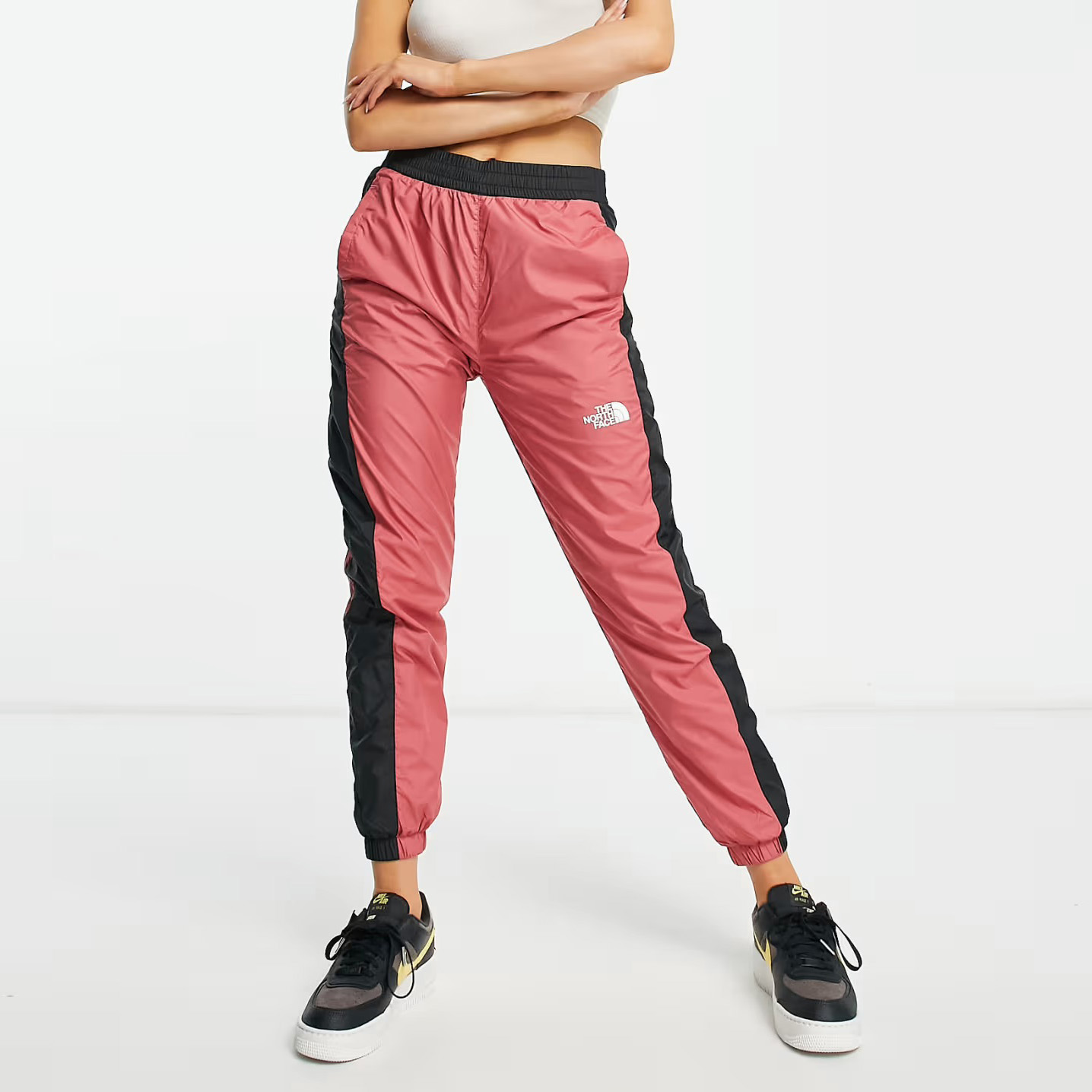 Calças desportivas rosa com riscas pretas e logo branco