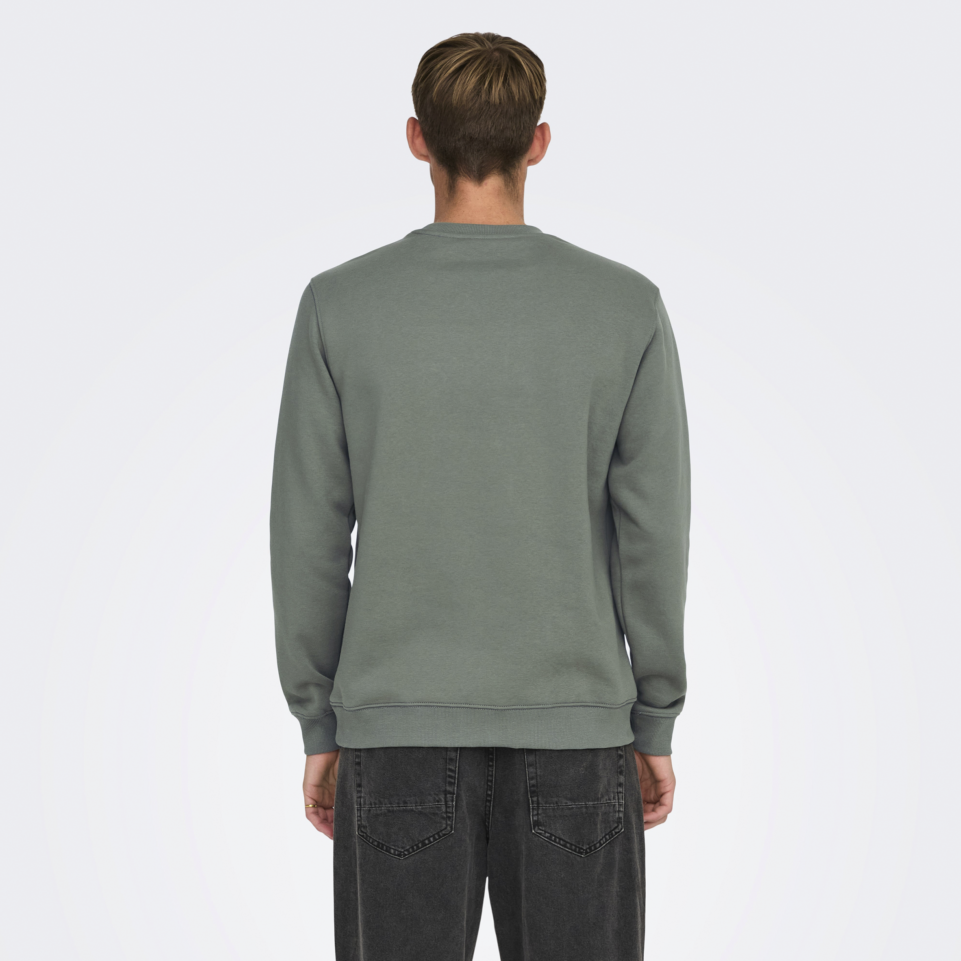 Pessoa de costas usando suéter verde cinza e calças pretas