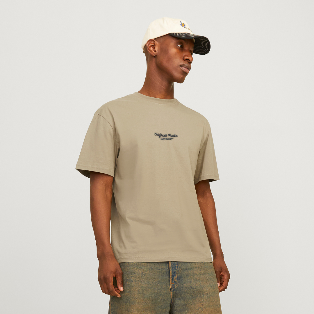 Homem a usar t-shirt bege e boné branco com aba preta