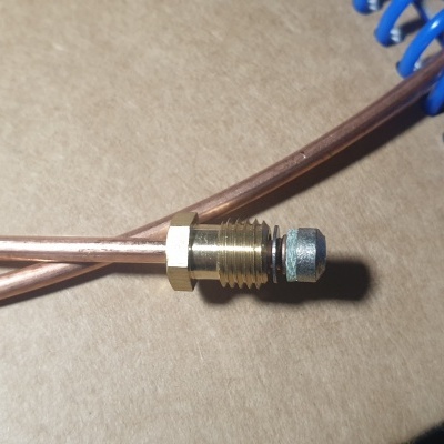 Conector metálico com porca em fios de cobre perto de mola azul