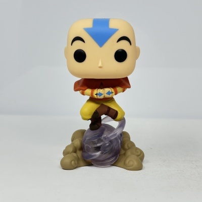 Figura Funko Pop do personagem Aang de Avatar em pose de meditação com roupa amarela e casaco castanho