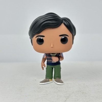 Figura Funko Pop com cabelo preto, camisa colorida, calças verdes e segura um copo de cocktail verde.
