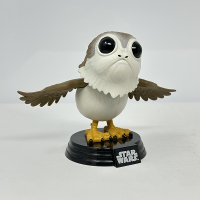 Figura Porg Star Wars em base preta sobre fundo cinzento