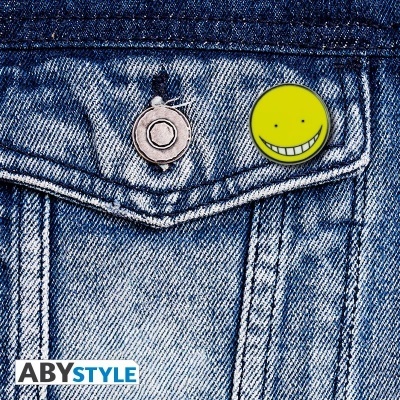 pin amarelo sorridente preso a bolso de camisa ou casaco jeans azul claro