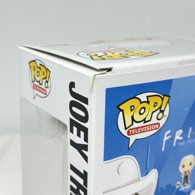 Caixa Funko Pop! branca com texto e personagem na frente, canto superior esquerdo danificado