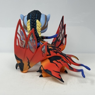 Figura de vinil azul com asas laranja e vermelhas e cabelo trançado