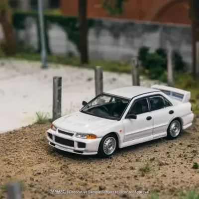 Miniatura de carro desportivo branco numa superfície de terra