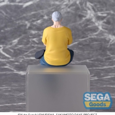 Figura colecionável de pessoa sentada de costas com camiseta amarela.