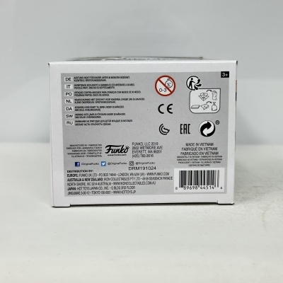 Caixa branca com texto multilingue, símbolos de segurança e código de barras.