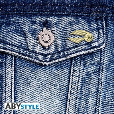 Bolso de jeans azul claro com duas pins metálicas, uma prateada e outra dourada