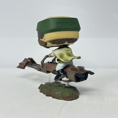 Figura Funko Pop de personagem com capa verde numa moto voadora castanha
