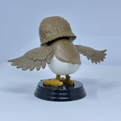 Figura de pássaro de plástico com asas abertas em suporte preto