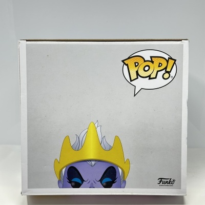Caixa Funko Pop com figura púrpura de olhos azuis e coroa amarela