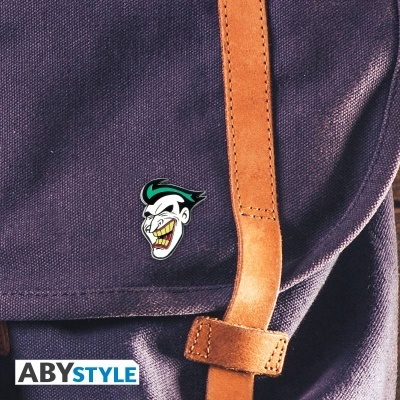 Mochila azul escura com alças de couro castanho e pin do Joker