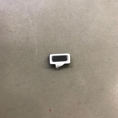 Pequeno acessório metálico prateado com inserção preta