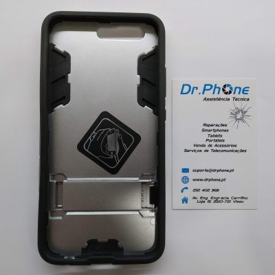 capa protetora para smartphone com bordas pretas e interior prateado ao lado de cartão de visita branco