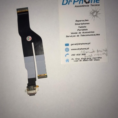 Cabo flexível preto com conectores dourados junto a cartão de visita da Dr Phone Assistência Técnica